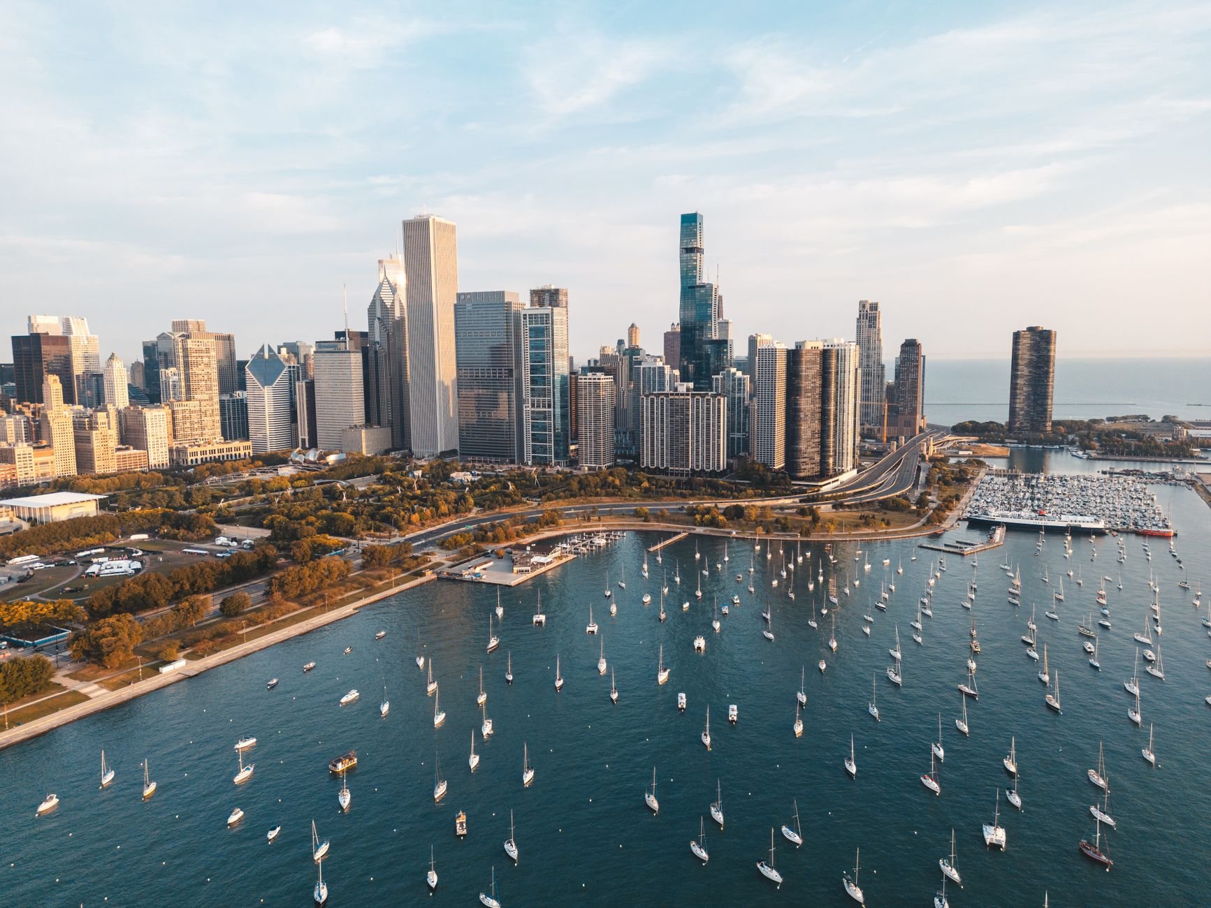 An aerial view of Chicago's skyline with a bustling marina filled with boats on a clear day.