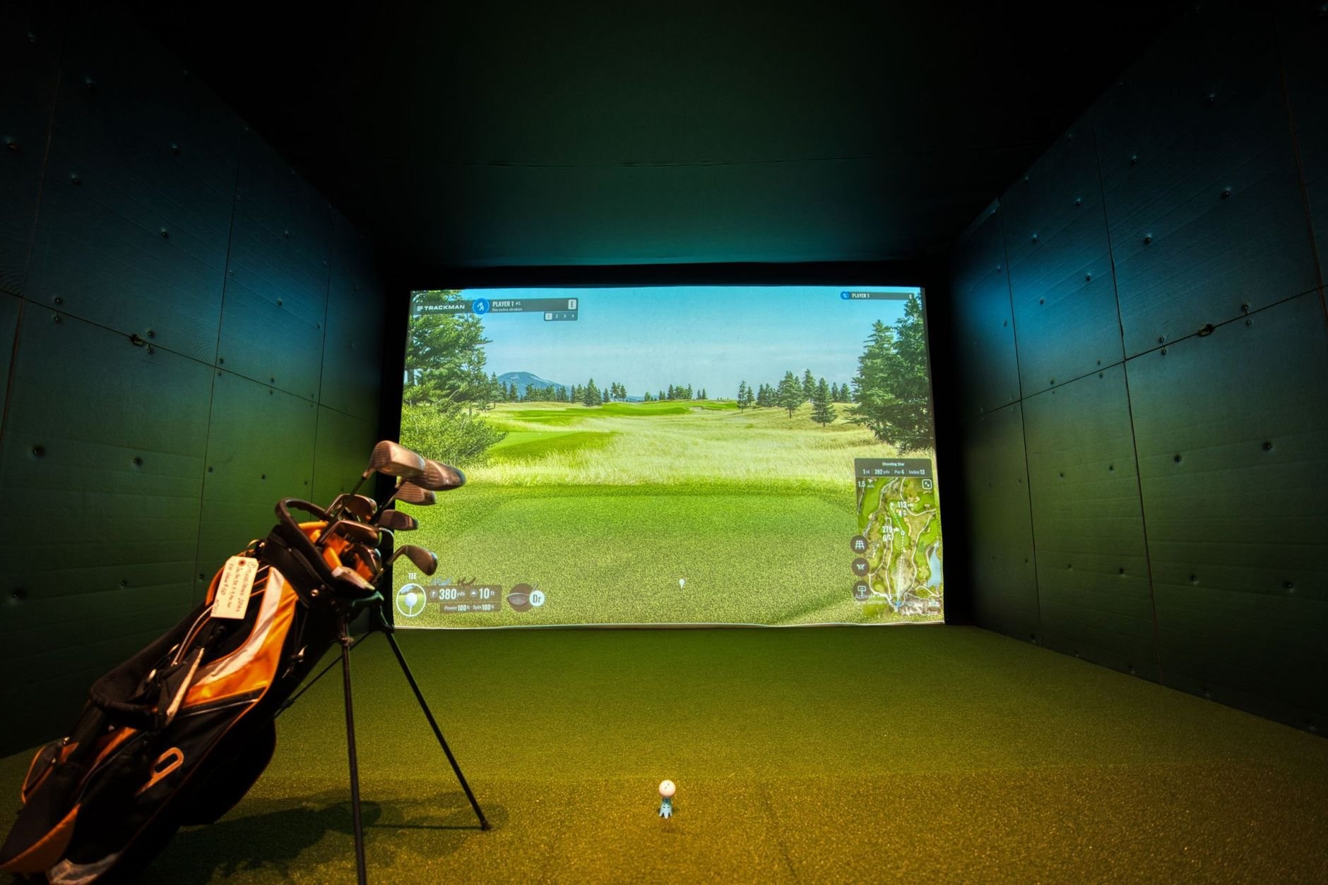 A modern indoor golf simulator with realistic course graphics.
